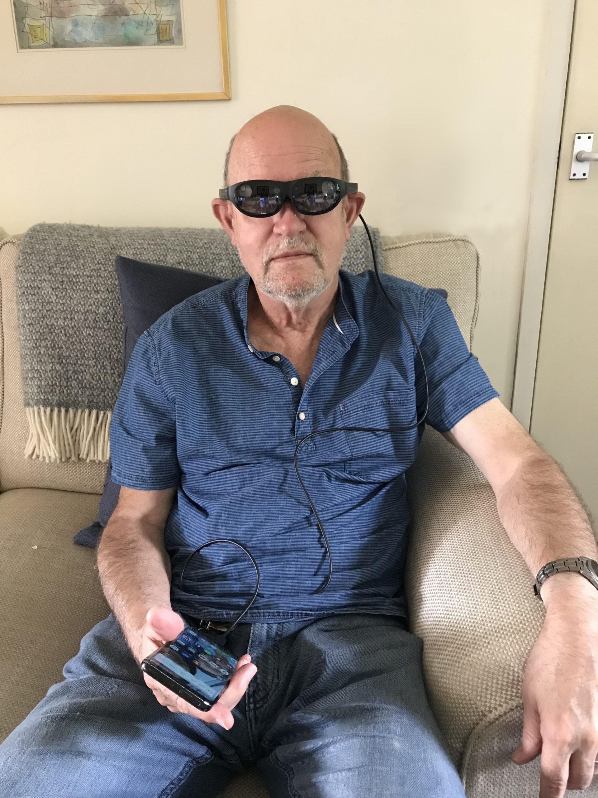 A man sitting on a sofa wearing a VR headset